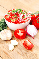 tomato salad in white bowl with bundle of chives