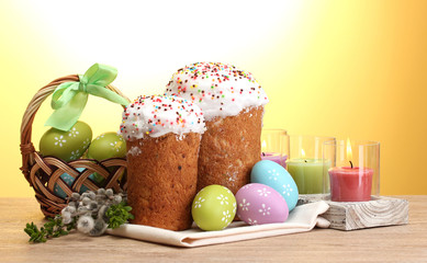 Beautiful Easter cakes, colorful eggs in basket and candles