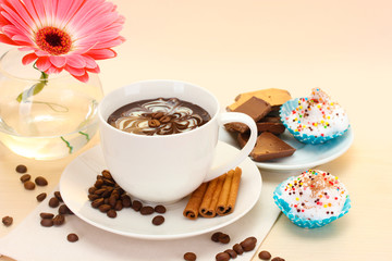 cup of coffee and gerbera, beans, cinnamon sticks