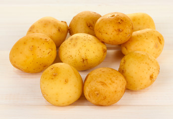 young potatoes on white wooden table close-up