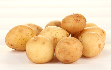 young potatoes on white wooden table close-up