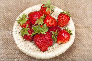 Strawberries in a wicker basket on the background of the canvas