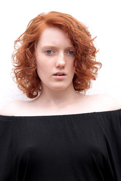 Eine rothaarige Frau mit sichtbaren Brustwarzen unter schwarzem Kleid