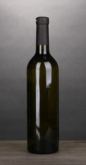 Bottle of great wine on wooden table on grey background