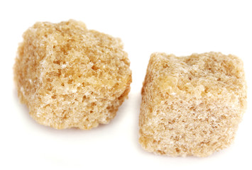 Lump brown cane sugar cubes isolated on white