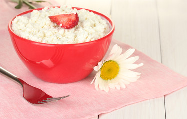 cottage cheese with strawberry in red bowl, fork and flower