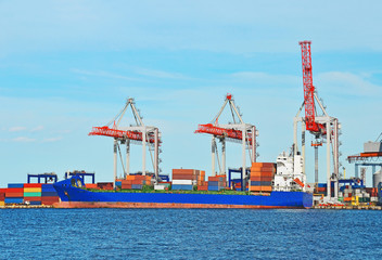 Fototapeta premium Container stack and ship under crane bridge