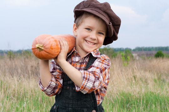 Smiling boy with pumpkin on his shoulder