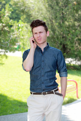 Unhappy man in park on telephone