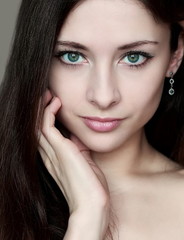 Obraz premium Fashion portrait of woman with sexy look holding face and long h