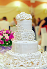 white floral wedding cake on restaurant interior background