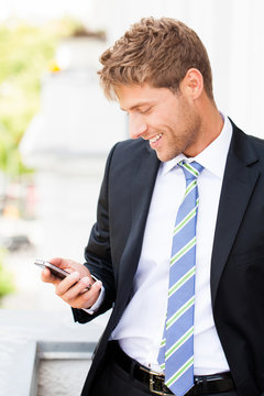 Geschäftsmann liest erfreut SMS