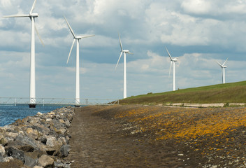 Wind turbines in a lake along a dam