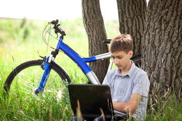 Teen in park with laptop