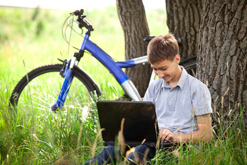 Teen in park with laptop