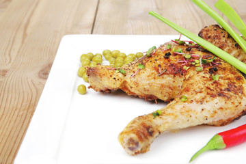 chicken garnished with green sweet peas and red hot pepper