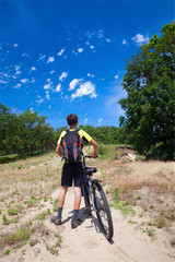 Obraz premium A teenager on a bicycle traveling in the forest