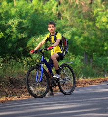 Fototapeta premium A teenager on a bicycle traveling in the forest