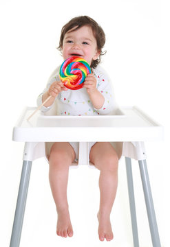 Baby laughing holding lollypop
