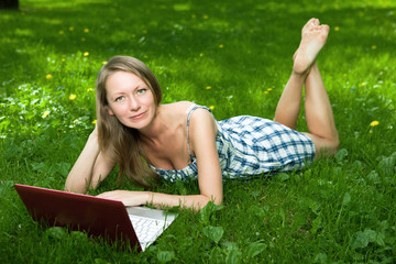 Attractive girl with a laptop in the park