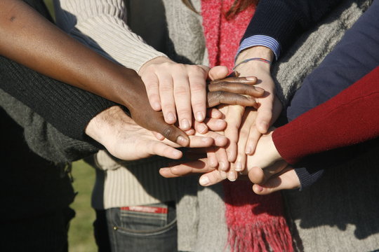 Young group with hands stacked together