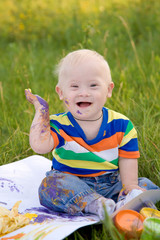 baby boy with Down syndrome painting finger paints