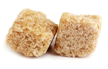 Lump brown cane sugar cubes isolated on white