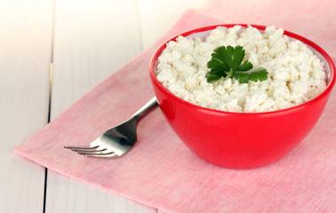 cottage cheese with parsley in red bowl and fork