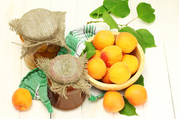 canned apricots and jam in a jars and ripe apricots in bowl