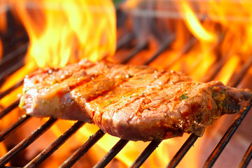 steak on grill with flames
