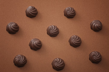 茶色の背景に並べたチョコレート