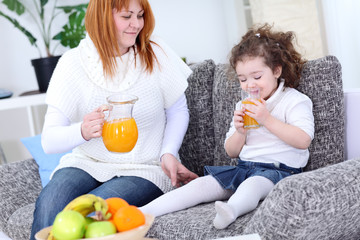 Mother and daughter drinking orange juice