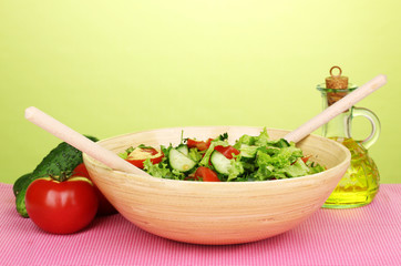 Fresh salad with tomatoes and cucumbers on green background