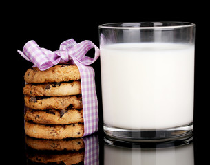 Glass of milk and cookies isolated on black