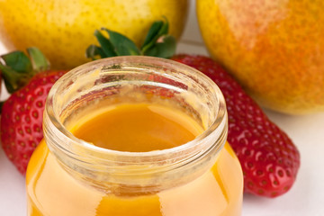 Baby puree and fruits on background