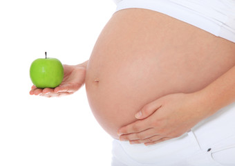 Schwangere Person hält grünen Apfel