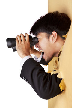 Shocked businessman looking with binoculars