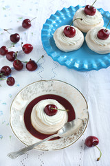 Meringue nests with cream and fresh sweet cherry