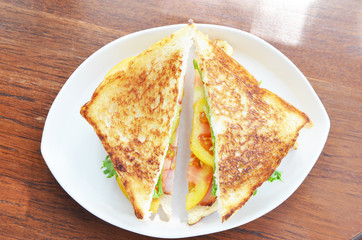Club sandwich with coffee on wood background