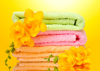 colorful towels and flowers on yellow background