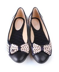 Female flat ballet shoes patterned with black polka