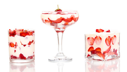 Glasses of ripe strawberries with cream isolated on white