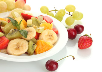 Fresh fruits salad on plate and berries isolated on white