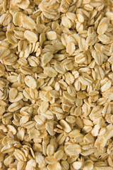 Oatmeal background, rolled raw oats macro closeup vertical
