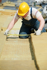 roofer worker measuring insulation material - obrazy, fototapety, plakaty