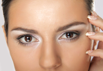 Naklejka premium Portrait of young woman with healthy skin touching her face