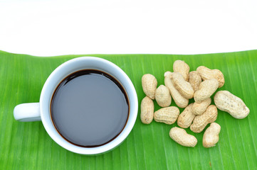 a cup of black coffee on banana leaf isolated