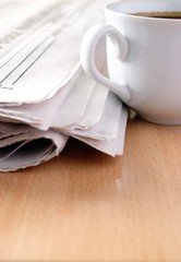 cup of coffee and the newspaper on the table
