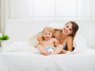 Fototapeta na wymiar Portrait of smiling mother and baby in bedroom