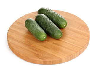 Fresh cucumbers on wooden board isolated on white